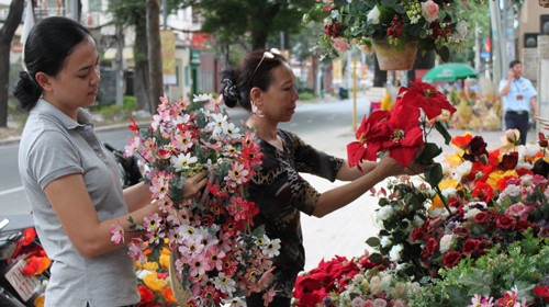 Hoa kiểng giả được khách chọn mua nhiều. Trong ảnh: khách hàng mua hoa trên đường Pasteur, TP.HCM