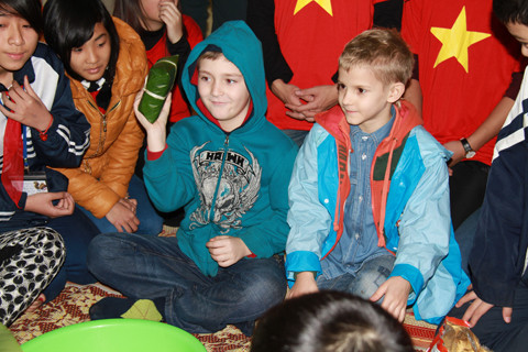 Hai em bé người Nga hào hứng xem chiếc bánh chưng Việt Nam. Ảnh: Trường Phong