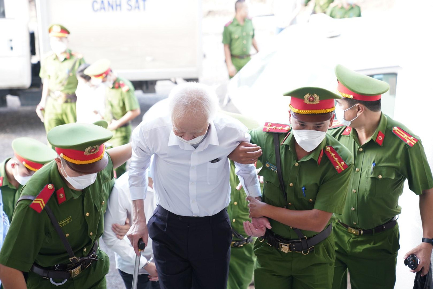 Bị cáo Trần Văn Minh phải có cán bộ dìu lên cầu thang.