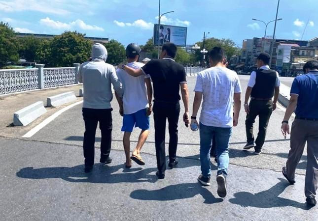 Nghi phạm mặc quần đùi xanh, áo trắng bị cơ quan chức năng khống chế.