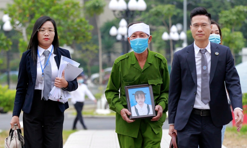 Ông Đỗ Hữu Chức ôm di ảnh cháu gái cùng luật sư đến tòa.