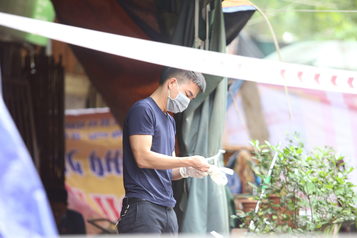 Cán bộ đeo găng tay chuẩn bị vào hiện trường khám nghiệm.