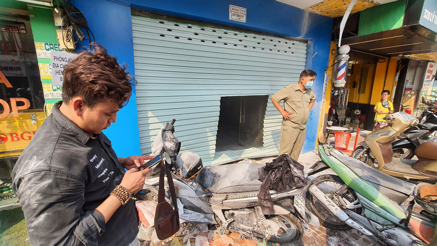 Lực lượng chức năng phải dùng thiết bị chuyên dụng để cắt cửa cuốn và tiến hành dập tắt đám cháy. Ảnh:CTV Lực lượng chức năng phải dùng thiết bị chuyên dụng để cắt cửa cuốn và tiến hành dập tắt đám cháy. Ảnh:CTV