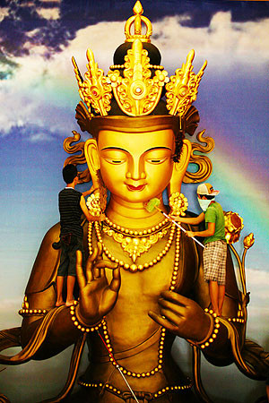 Hai người đàn ông Trung Quốc sinh sống tại Indonesia đang lau bức tượng Phật để đón năm mới