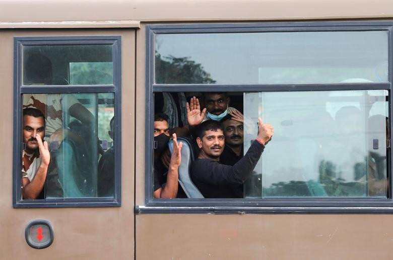 Những người được sơ tán khỏi Kabul vẫy tay chào khi lên xe buýt rời căn cứ không quân Hindon ở Ghaziabad, Ấn Độ, ngày 17/8.