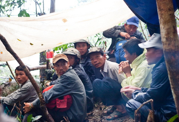 Một nhóm người săn kỳ nam quê ở Vạn Ninh cùng ngồi chờ mưa tạnh trong túp lều tạm bợ giữa rừng