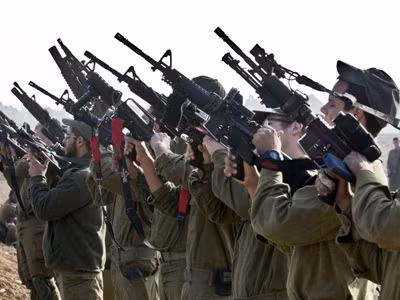 Lính Israel thuộc một trung đoàn xe bọc thép kiểm tra vũ khí gần biên giới với Dải Gaza. Ảnh: Getty Images