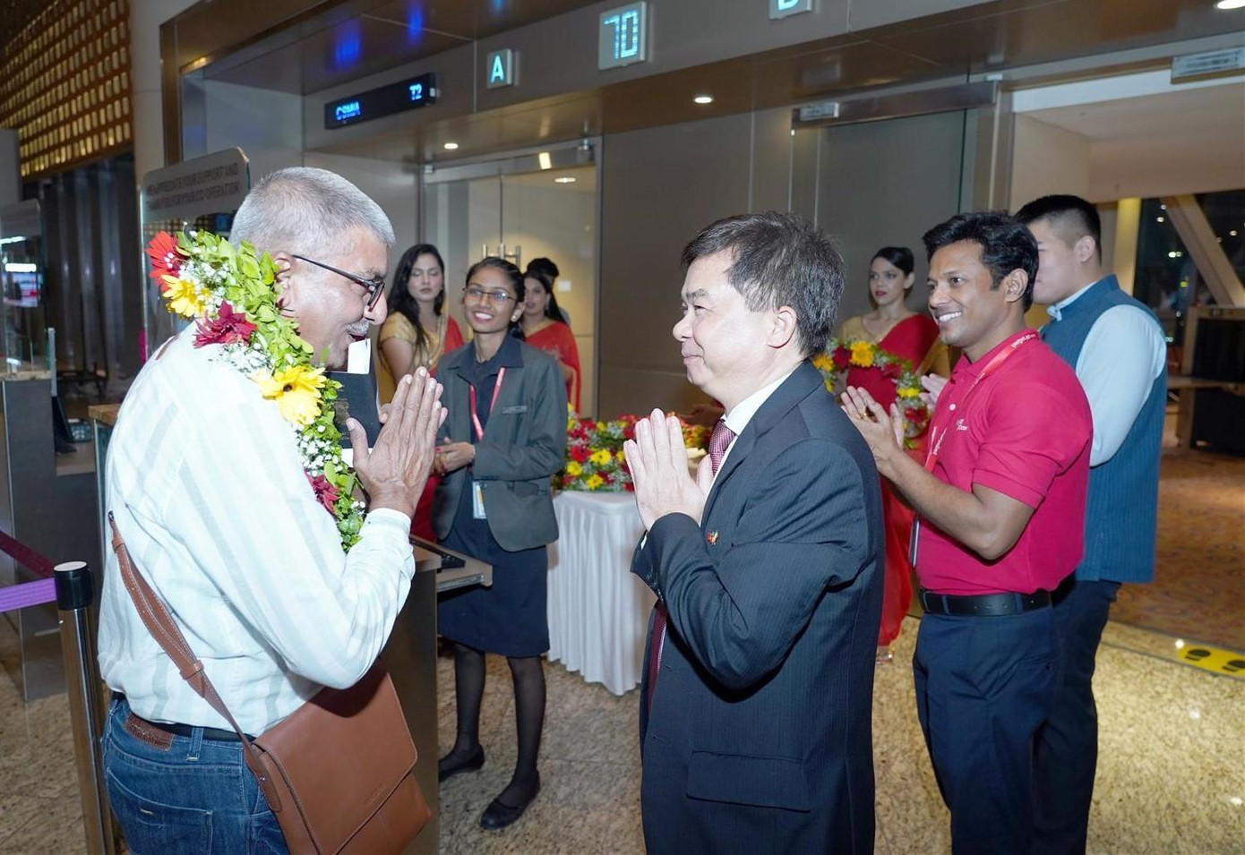 Tổng lãnh sự Việt Nam tại Mumbai - ông Hoàng Tùng (thứ 3 từ trái sang) tham dự nghi thức chào mừng và tặng hoa hành khách trên chuyến bay đầu tiên kết nối thành phố Mumbai với thành phố Đà Nẵng