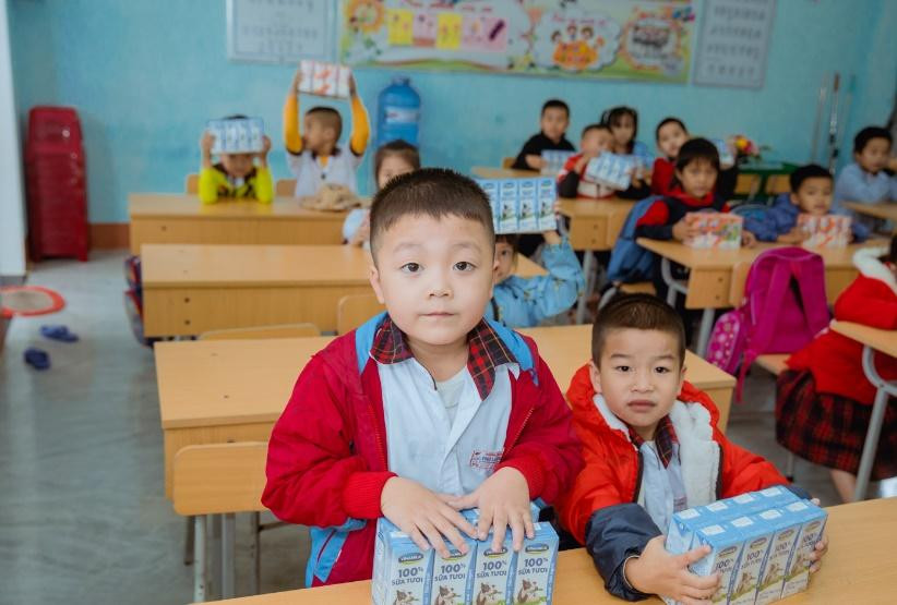 Các em học sinh tại Quảng Nam và Huế vui mừng khi nhận sữa Vinamilk từ đoàn hỗ trợ.