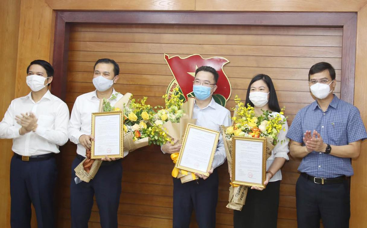 Anh Bùi Quang Huy và anh Nguyễn Ngọc Lương trao Quyết định và hoa chúc mừng các anh, chị vừa được điều động, phân công. Ảnh: Lâm Đăng Hải