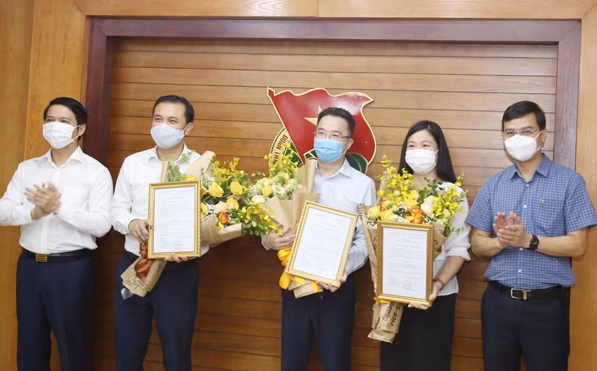 Anh Bùi Quang Huy và anh Nguyễn Ngọc Lương trao Quyết định và hoa chúc mừng các anh, chị vừa được điều động, phân công. Ảnh: Lâm Đăng Hải