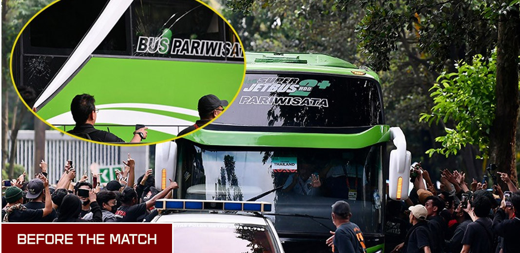 Tấm kính chắn gió của xe bus chở đội tuyển đã vỡ, bên cạnh là rất nhiều CĐV có cử chỉ không đẹp