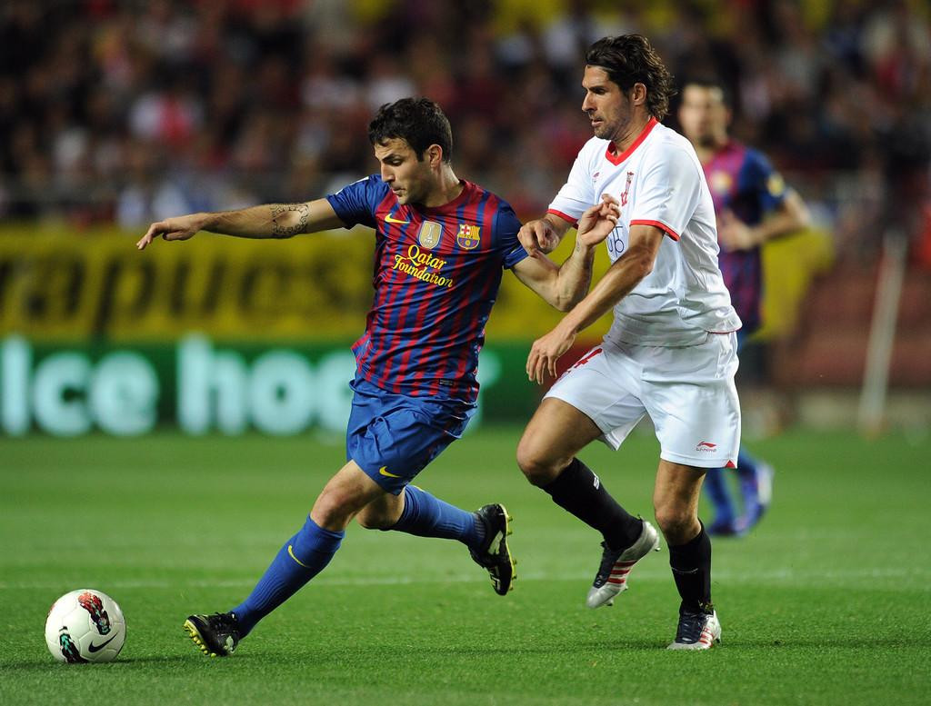 Escude theo kèm Fabregas (trái) trong trận Sevilla gặp Barca