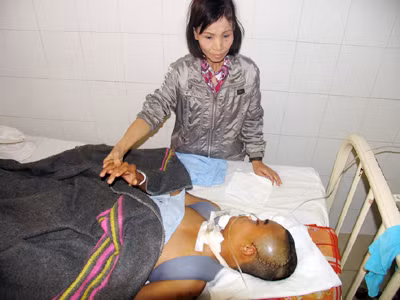 Chị Tuyến chăm sóc con trai đang bất tỉnh tại bệnh viện