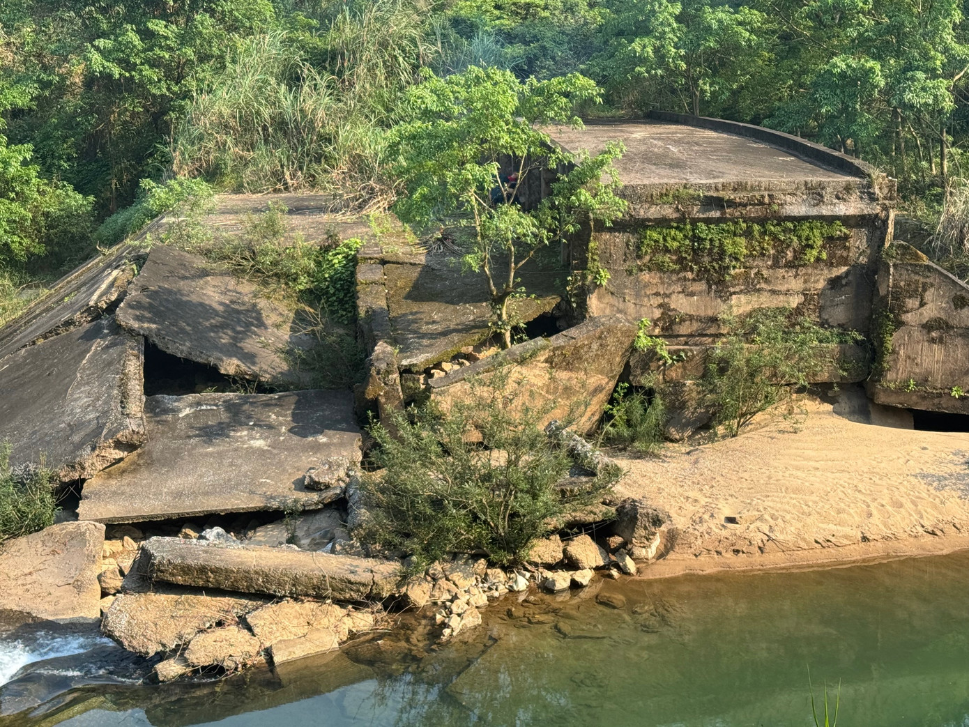 Những mảng bê tông nặng hàng tấn nằm chỏng chơ dưới lòng suối. Những mảng bê tông nặng hàng tấn nằm chỏng chơ dưới lòng suối.