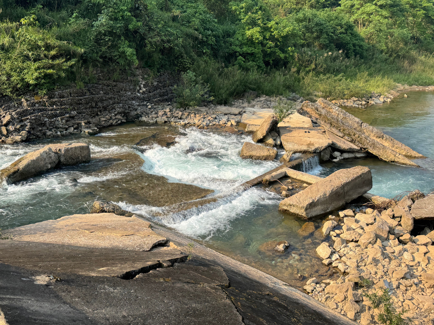 Những mảng bê tông nặng hàng tấn nằm chỏng chơ dưới lòng suối. Những mảng bê tông nặng hàng tấn nằm chỏng chơ dưới lòng suối.