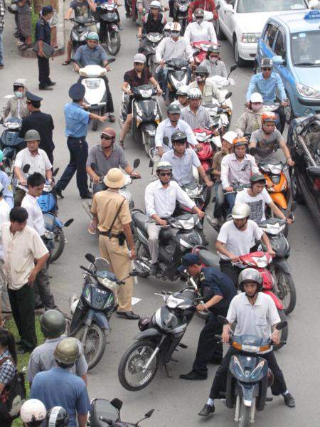 Cảnh sát giao thông dẹp những chiếc xe dừng đỗ dưới lòng lề đường gây ùn tắc.