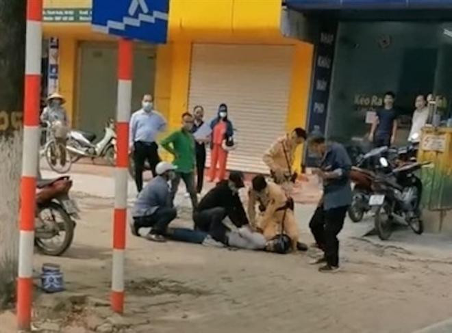 Lực lượng chức năng và người dân khống chế đối tượng Định. Ảnh:Zing Lực lượng chức năng và người dân khống chế đối tượng Định. Ảnh:Zing