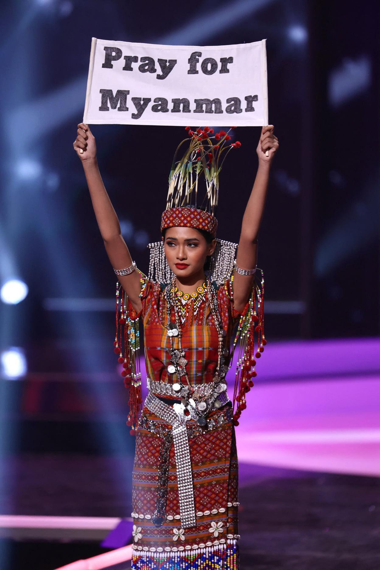 Hoa hậu Hoàn vũ Myanmar giơ tấm bảng "Cầu nguyện cho Myanmar" trong phần thi Trang phục dân tộc tại Miss Universe 2020. Hoa hậu Hoàn vũ Myanmar giơ tấm bảng "Cầu nguyện cho Myanmar" trong phần thi Trang phục dân tộc tại Miss Universe 2020.