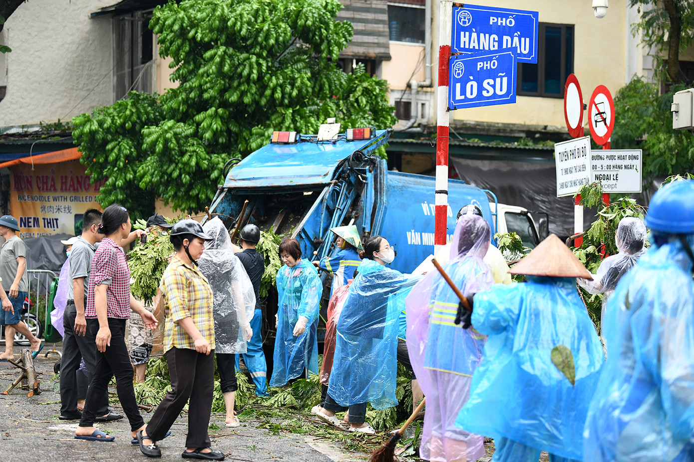 Trên tuyến phố Hàng Dầu-Lò Sũ vào chiều nay, nhân viên công ty cây xanh Hà Nội cùng những nguời dân nơi đây dọn dẹp những cành cây gãy đổ. Ảnh: Như Ý