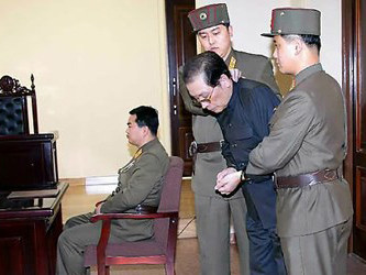 Jang Song-thaek bị hai nhân viên an ninh Triều Tiên bắt cúi đầu trong phiên tòa hôm 12/12. Jang Song-thaek bị hai nhân viên an ninh Triều Tiên bắt cúi đầu trong phiên tòa hôm 12/12