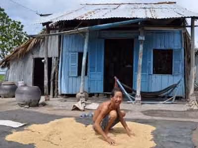 Ông Trần Văn Danh hơn 20 năm trồng lúa, ngồi trước ngôi nhà tồi tàn. ẢNH: HỒNG LĨNH