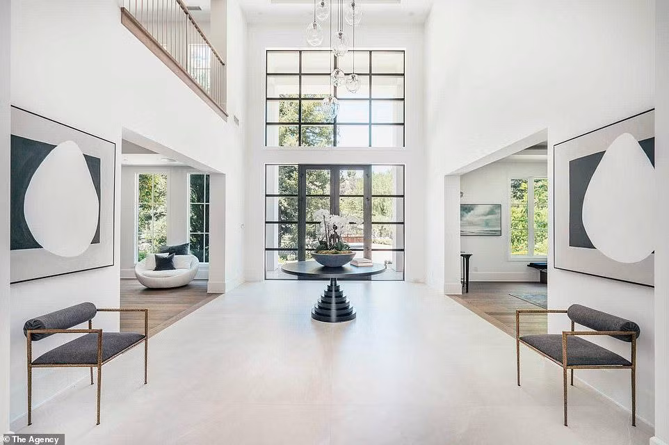 Thiết kế bên trong tối giản với tường trắng, sàn gỗ cứng nhiều tông màu và nhiều ánh sáng tự nhiên.