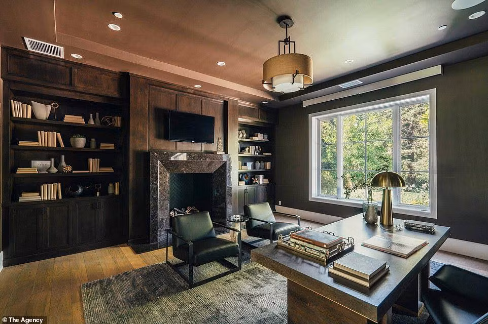 Phòng làm việc có tông màu trầm hơn, tích hợp sẵn kệ sách và lò sưởi, cửa sổ kính lớn lấy ánh sáng tự nhiên, cũng tạo độ thông thoáng.