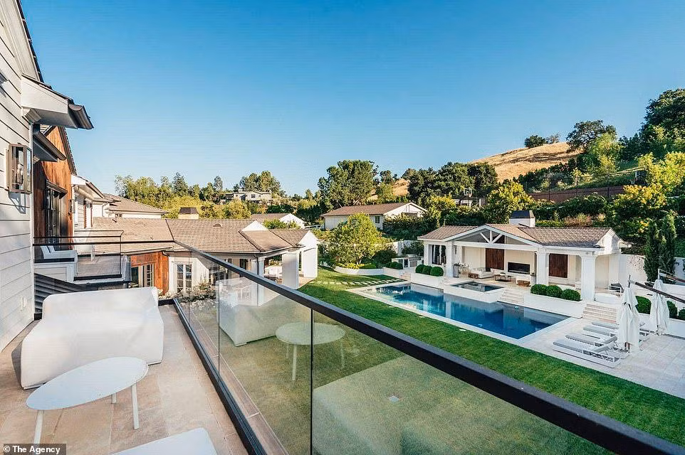 Ban công của các phòng ngủ có lan can bằng kính và tầm nhìn ra những ngọn đồi vàng hoang vắng và hồ bơi.