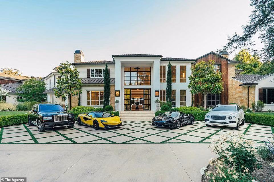 Mặt trước của nhà chính có nhiều cửa sổ ở cả tầng một và tầng hai, nhìn ra sân bê tông rộng, đủ sức chưa nhiều xe ô tô.