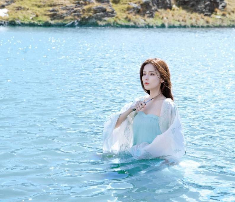 Trong loạt ảnh, mỹ nhân Tân Cương 29 tuổi mặc trang phục mỏng manh, mái tóc xõa tự nhiên, ngâm mình dưới sông. Gương mặt cô trông thảng thốt, mắt long lanh, tay kề dao vào cổ cho thấy tình thế nghiêm trọng.