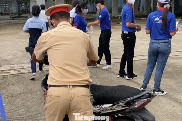 Cán bộ CSGT hỗ trợ đưa xe của cán bộ coi thi về điểm thi