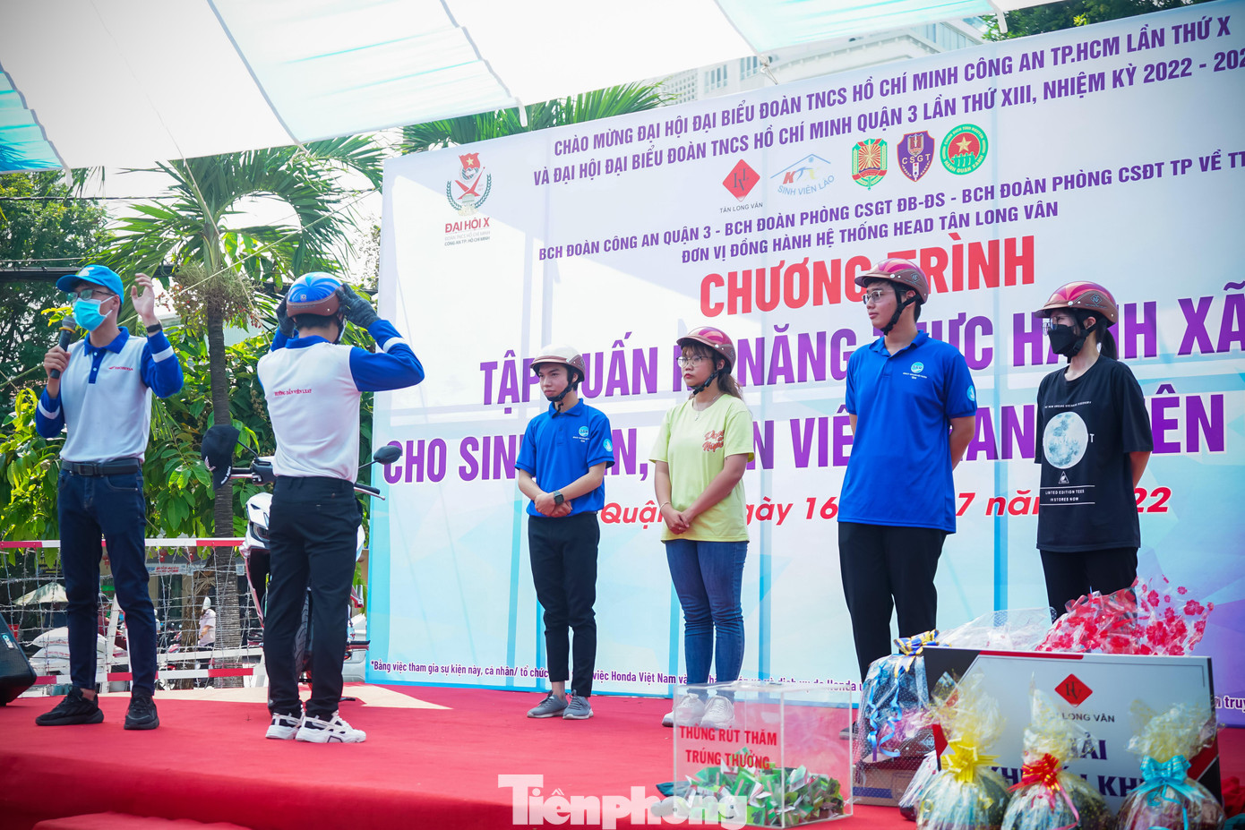 Các nhân viên hướng dẫn sinh viên đội mũ bảo hiểm đúng cách