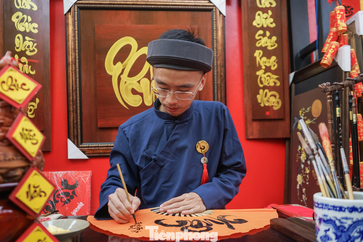 Ông đồ trẻ Nguyễn Xuân Chân Thành trổ tài cho chữ trên quạt tặng người dân