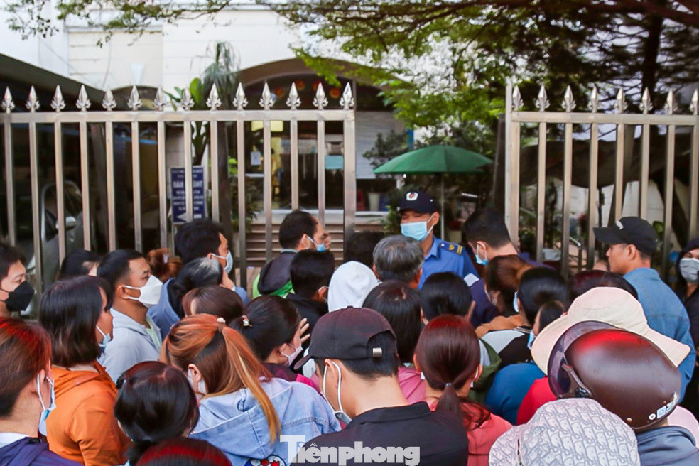 6h30 sáng 12/4, thấy bảo vệ bên trong trụ sở Bảo hiểm xã hội chuẩn bị mở cổng, nhiều người nhanh chóng thu xếp đồ đạc đứng chờ lấy số thứ tự vào làm thủ tục