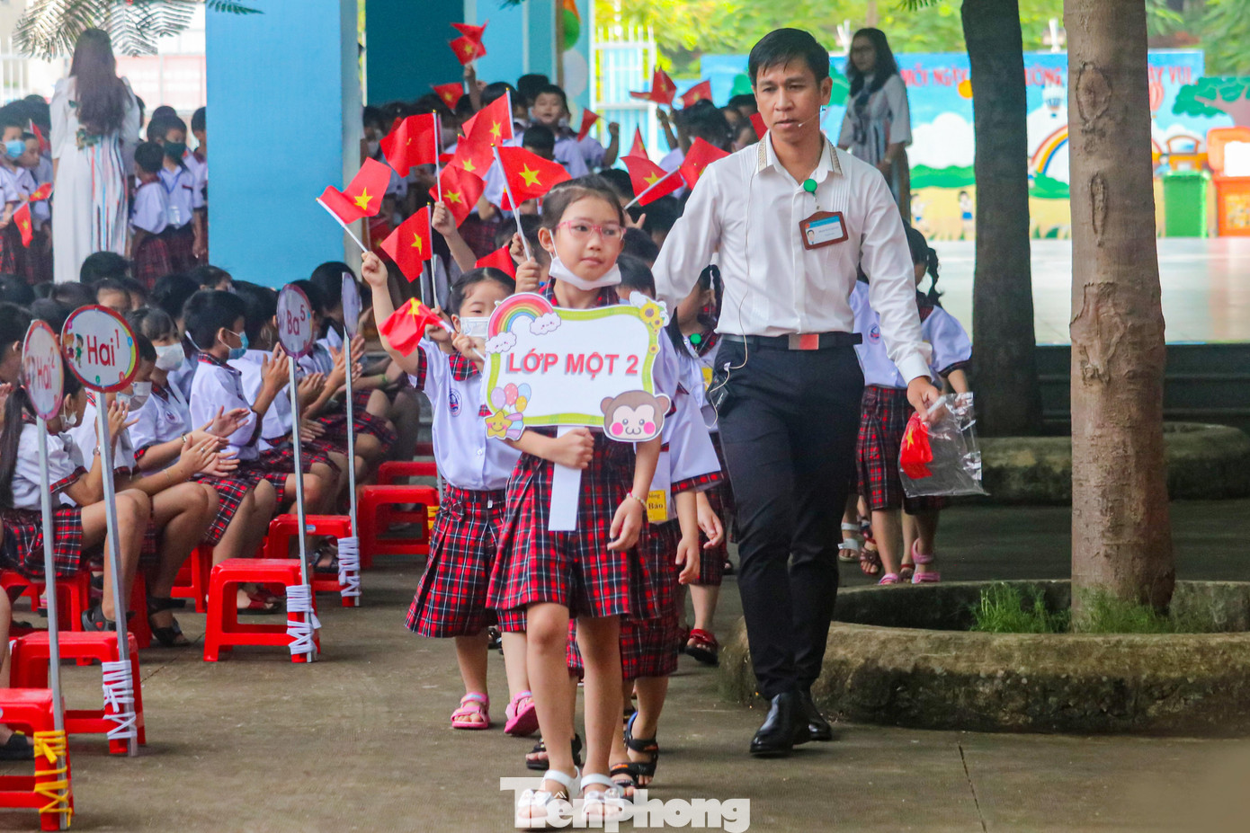 Đúng 7h30, Lễ khai giảng bắt đầu bằng việc chào đón học sinh lớp 1. Các em lần lượt xếp hàng theo lớp và được thầy cô chủ nhiệm dẫn vào. Trên tay các em cầm cờ Tổ quốc. Không khí khai trường rộn ràng khiến các phụ huynh và học sinh đều phấn khởi.