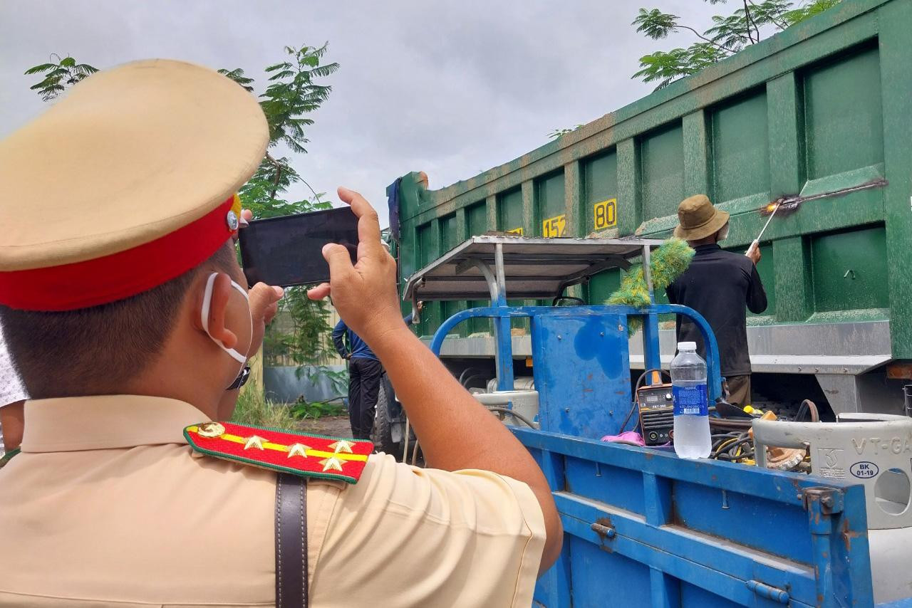 Cán bộ CSGT quay video giám sát việc cắt thùng xe Cán bộ CSGT quay video giám sát việc cắt thùng xe