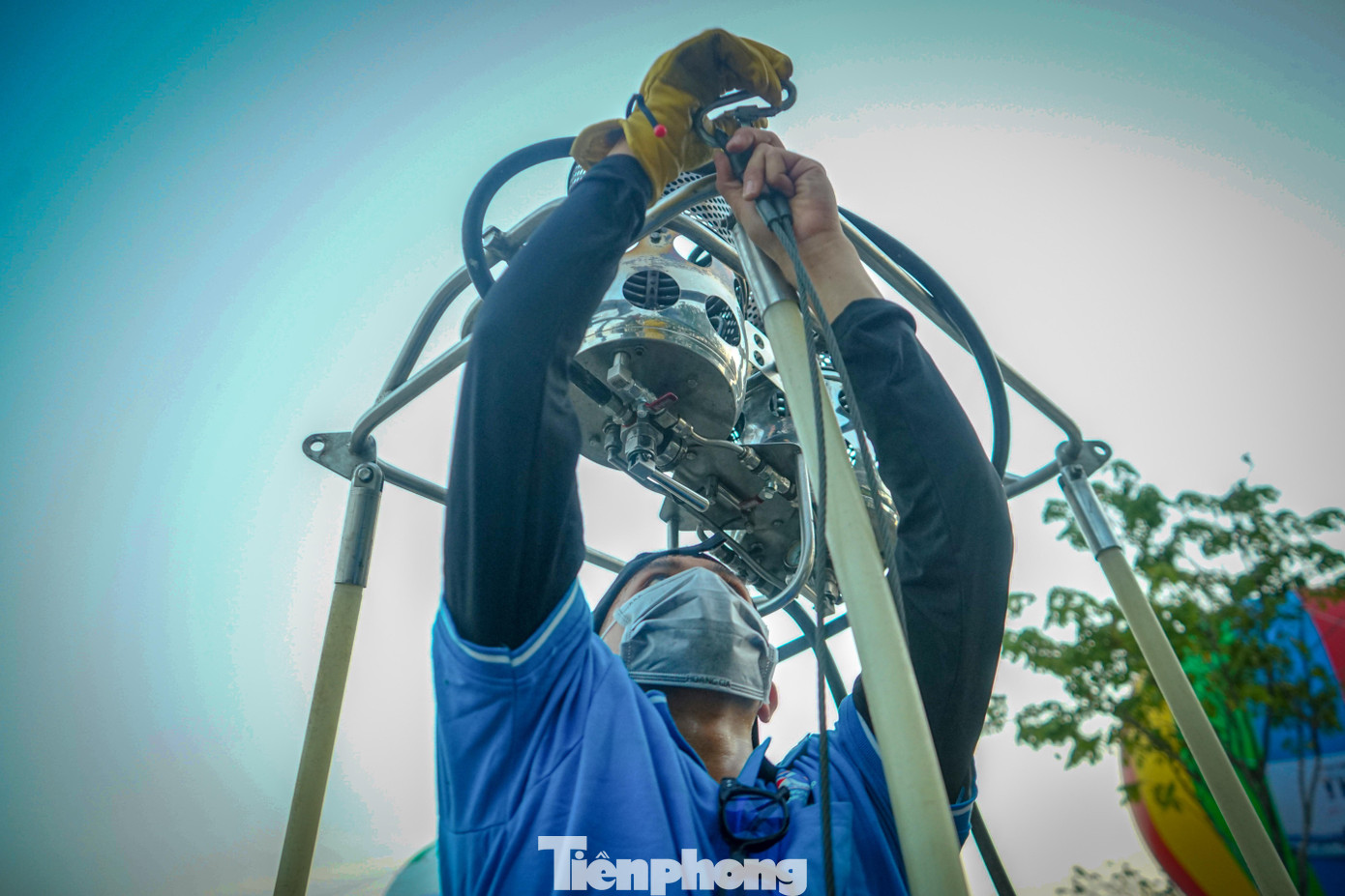 Một phi công trẻ lắp ráp các dây neo an toàn cho khinh khí cầu trước khi bơm khí bay lên Một phi công trẻ lắp ráp các dây neo an toàn cho khinh khí cầu trước khi bơm khí bay lên