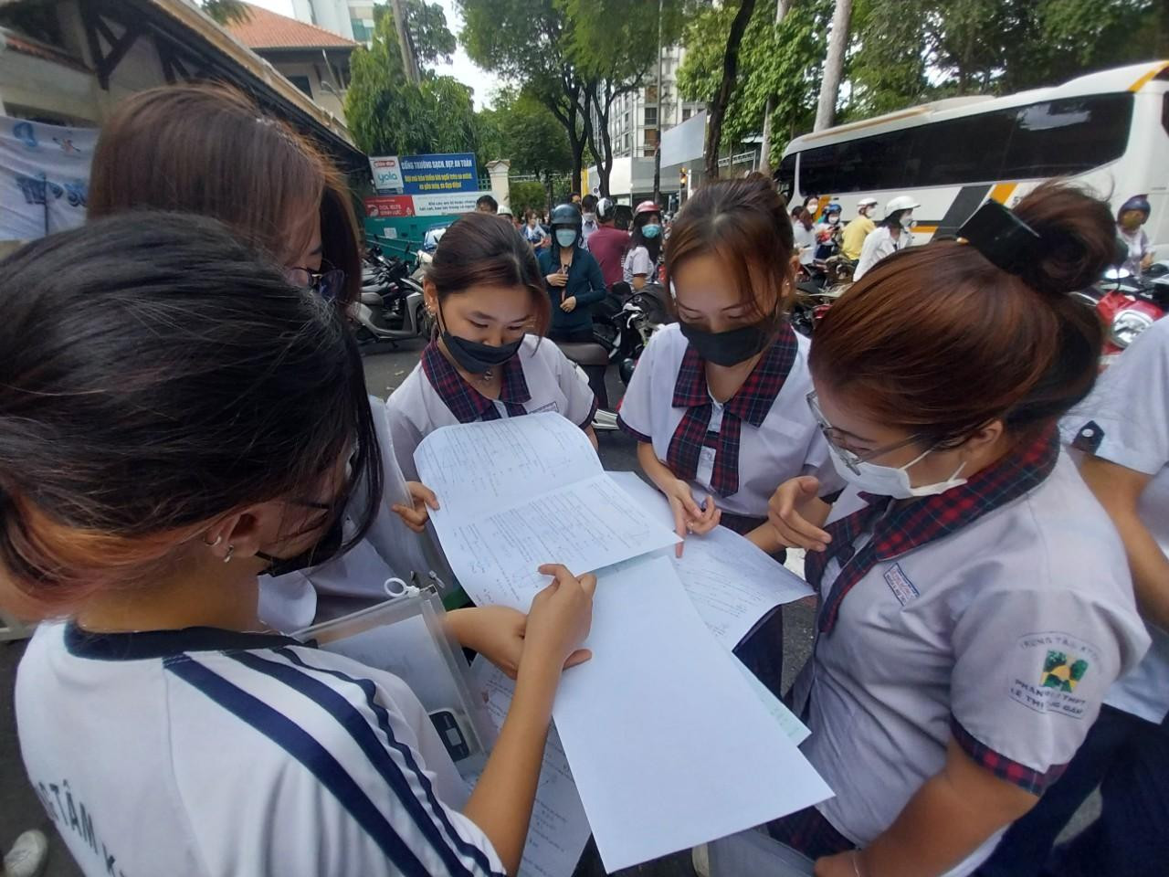 Một nhóm thí sinh trung tâm GDTX quận 3 so sánh đáp án tại điểm thi