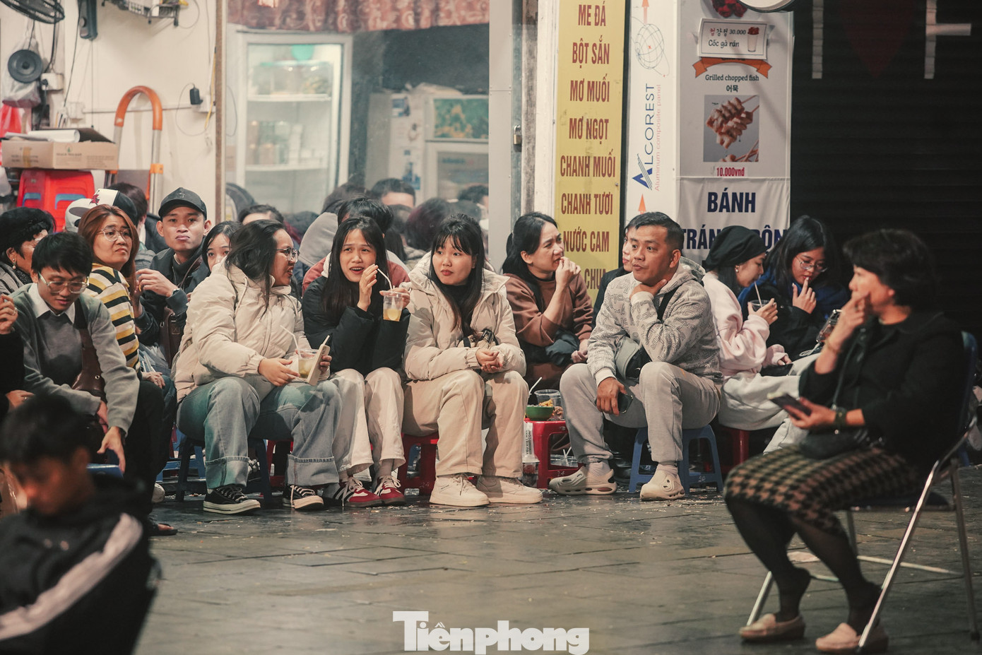 Hàng chục người ngồi co ro tại một quán nước ven đường. Hàng chục người ngồi co ro tại một quán nước ven đường.