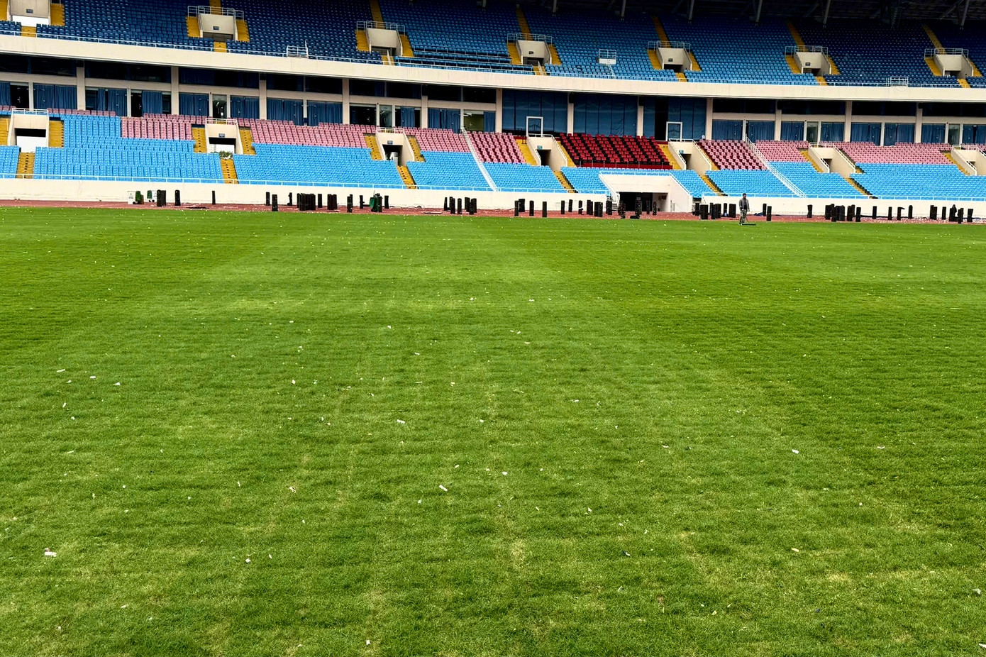 Mặt sân bị chia thành các ô bàn cờ, cỏ xơ xác và không còn đạt tiêu chuẩn.