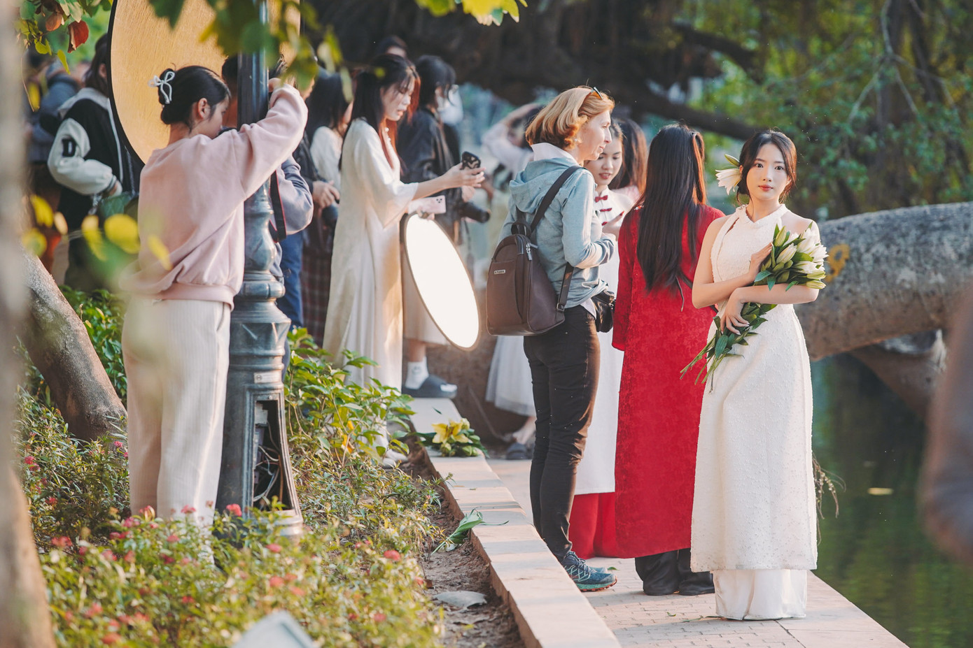 Những ngày qua, nhiệt độ ở Hà Nội khoảng 15-20 độ, thời tiết hơi se lạnh phù hợp để chụp ảnh Tết. Tại các khu vực hồ Hoàn Kiếm, phố cổ, Phan Đình Phùng, chợ Đồng Xuân... xuất hiện rất nhiều các &quot;nàng thơ&quot; diện áo dài, cầm hoa, thả dáng trước ống kính để có một bộ ảnh mang phong cách Tết.