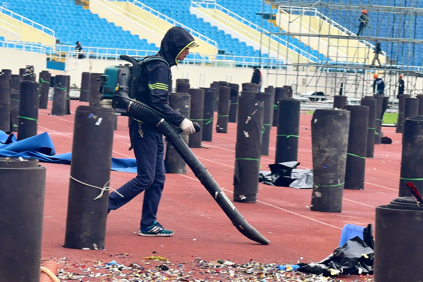 Nhân viên vệ sinh dùng máy thổi công nghiệp thổi những dây kim tuyến, giấy rác.