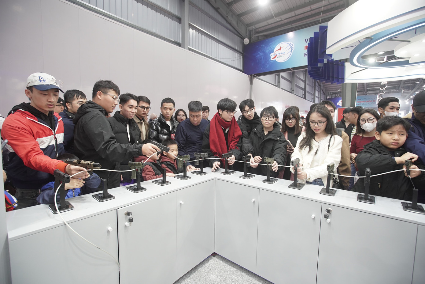 Người dân đứng quây kín các gian hàng thử súng.