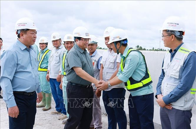 Thủ tướng Phạm Minh Chính với công nhân thi công cao tốc Cần Thơ - Cà Mau đoạn qua huyện Phụng Hiệp, tỉnh Hậu Giang. Ảnh: Dương Giang/TTXVN