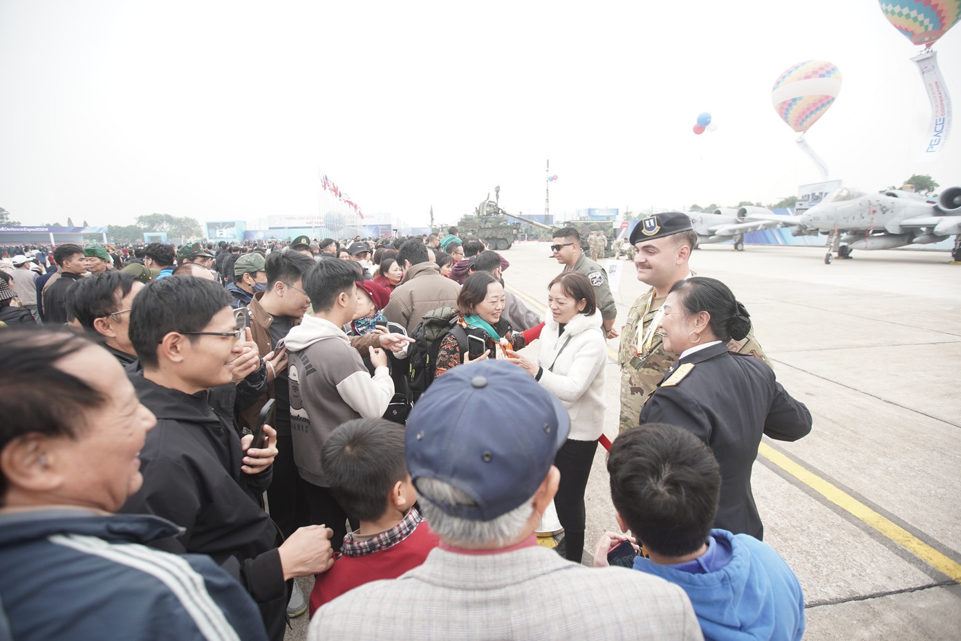 Người dân và du khách giao lưu chụp ảnh với những chiến sĩ nước ngoài.