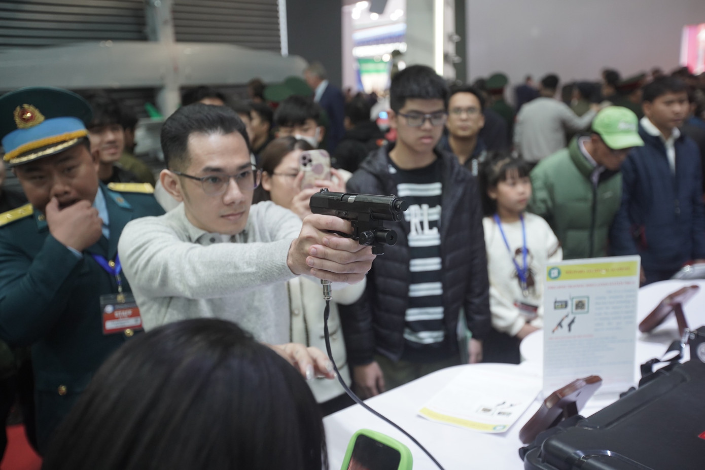 Người dân và du khách xếp hàng trải nghiệm bắn súng mô phỏng tại một gian hàng.