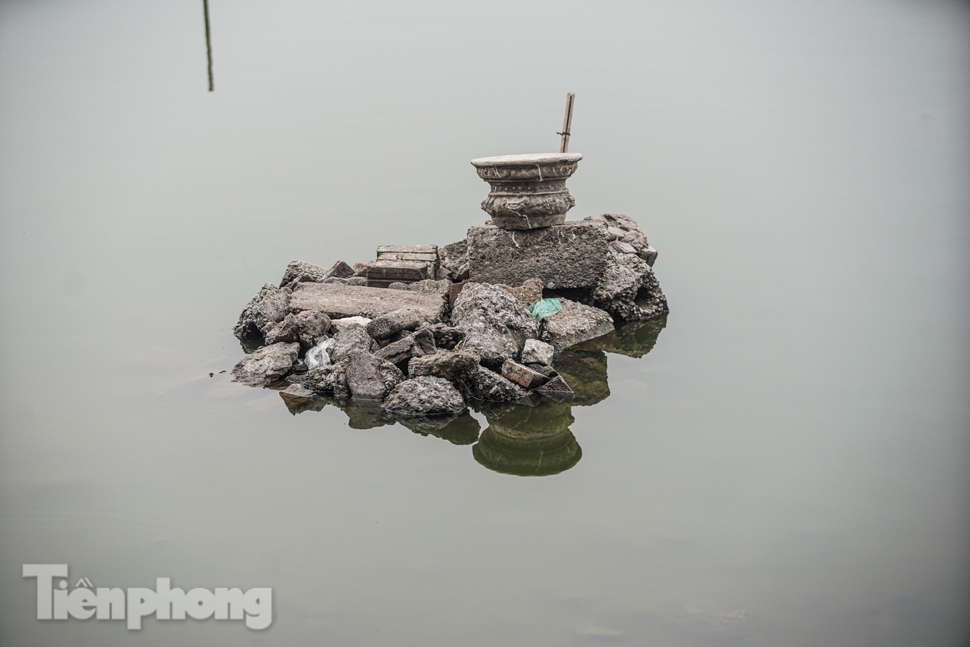 Những bát hương, đồ thờ bị đẩy dạt vào ven bờ.