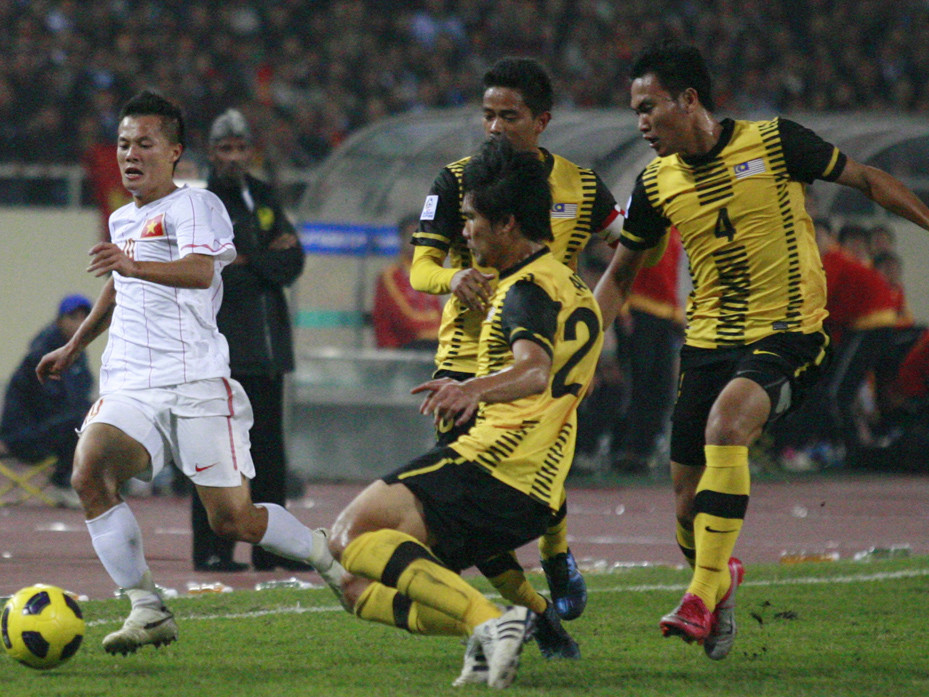 Hậu vệ Malaysia (áo vàng)luôn xuất hiện đông đảo mỗi khi cầu thủ Việt Nam có bóng. Ảnh: Hồng Vĩnh