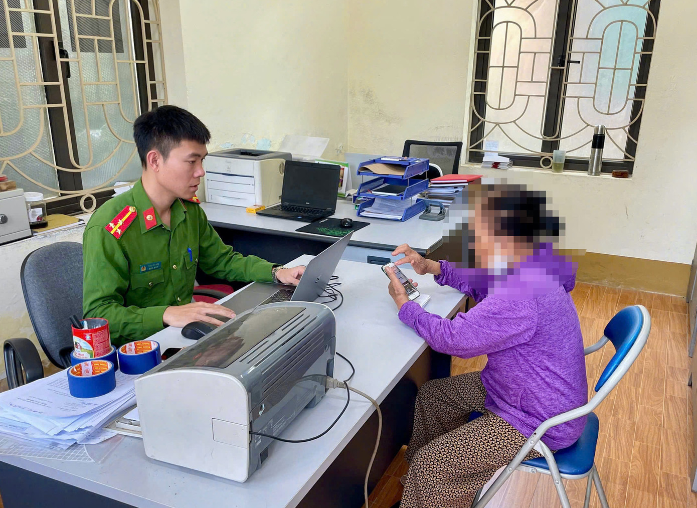 Cán bộ Công an phường Thảo Nguyên giải thích cho bà L về thủ đoạn của bọn lừa đảo.